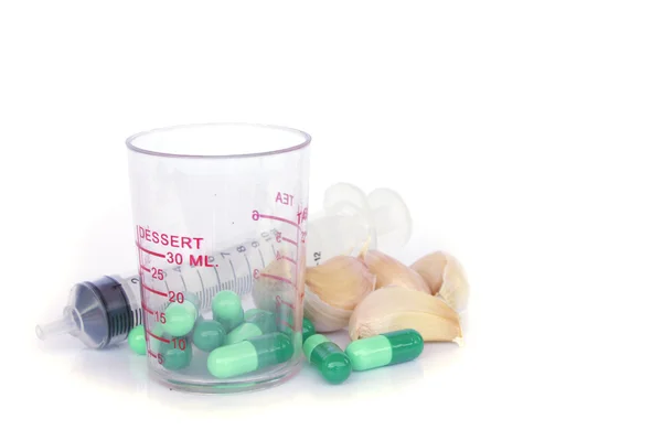 Gyógynövény tabletta és a fokhagyma, a világos színű háttér — Stock Fotó