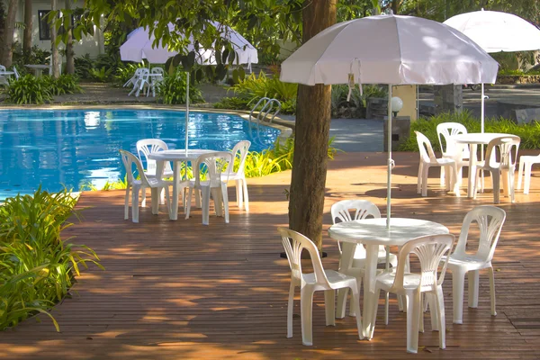 white plastic garden furniture table and chairs summer evening -