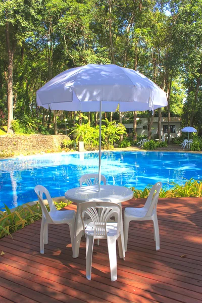 white plastic garden furniture table and chairs summer evening -