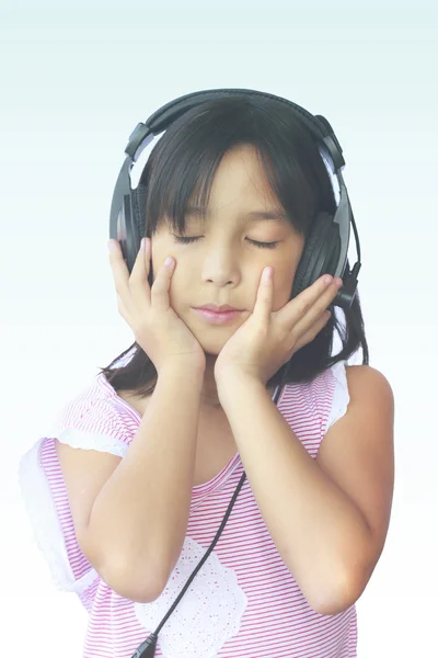 Ásia menina usando fones de ouvido no fundo branco — Fotografia de Stock