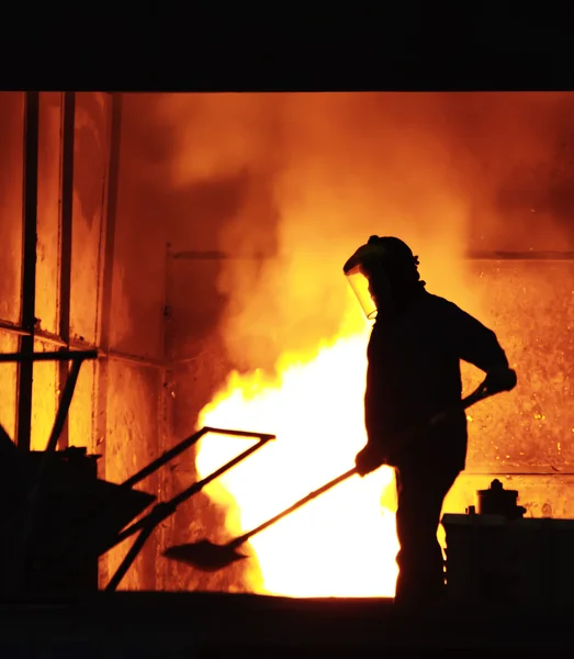 Man werkt in het spatten gesmolten ijzer - Stock beeld — Stockfoto
