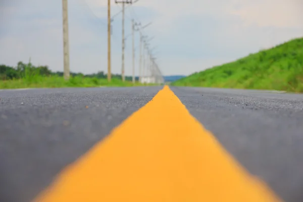 Archivbild - leere Straße und die gelben Verkehrslinien mit Wolken — Stockfoto