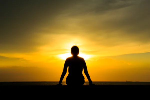 Silhueta de uma mulher contra o céu ao pôr do sol — Fotografia de Stock