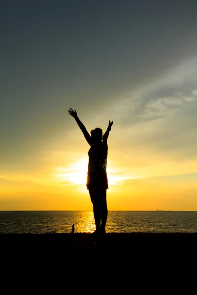 Silhouette of a woman against the sky at sunset — Stock Photo, Image