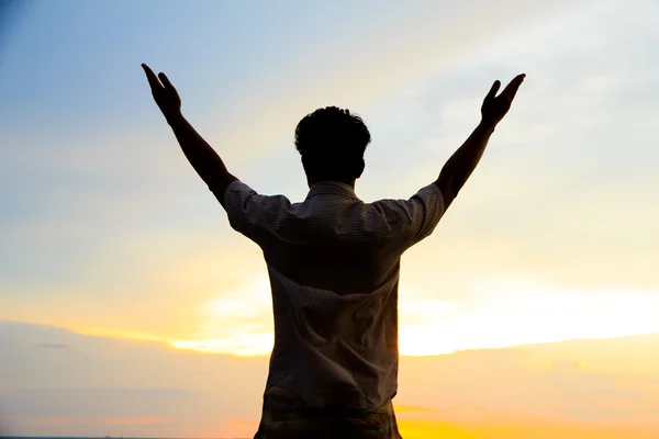 Foto stock - silhueta de ação homem único ao pôr do sol . — Fotografia de Stock