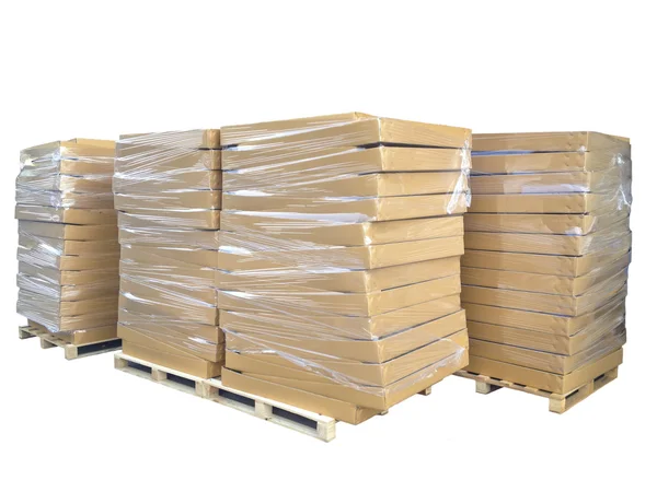 Склад фото - стопки картонных коробок на деревянных поддонах изолята — стоковое фото