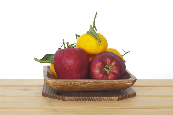 Voorraad foto Bowl van rode appels, oranje op houten tafel op witte achtergrond — Stockfoto