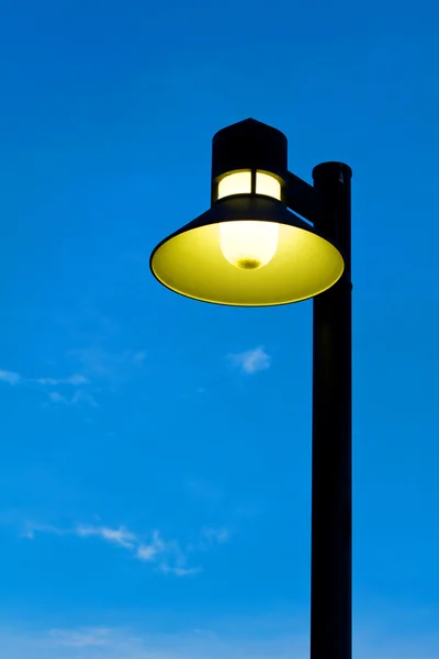 Luz de calle adornada contra un fondo azul del cielo — Foto de Stock