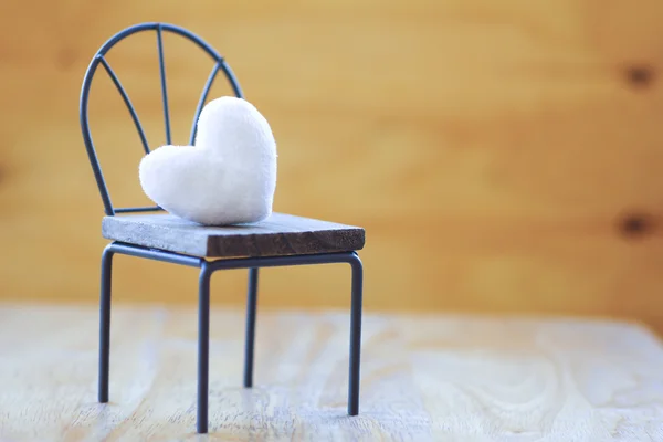 Stock Photo white heart on wooden chair with vintage pattern — Stock Photo, Image