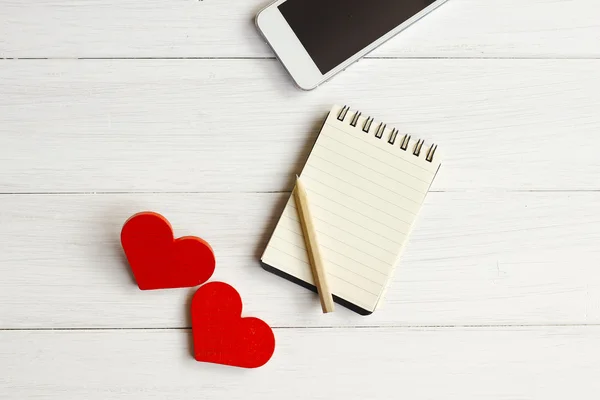 Foto de stock Corazón rojo de madera con portátil y teléfono móvil en tablas de madera blanca —  Fotos de Stock