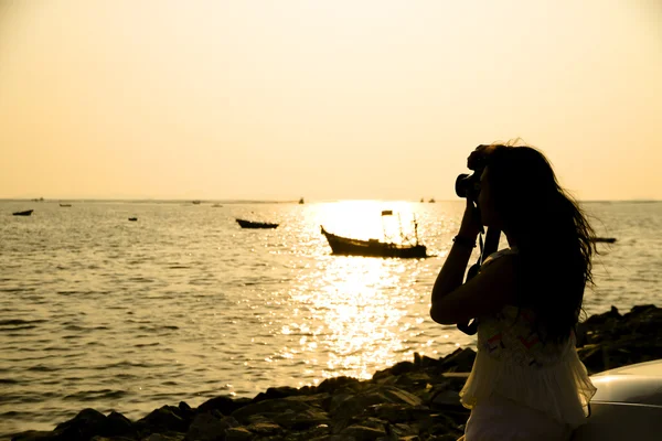 Mujer fotógrafa paisaje marino al atardecer —  Fotos de Stock