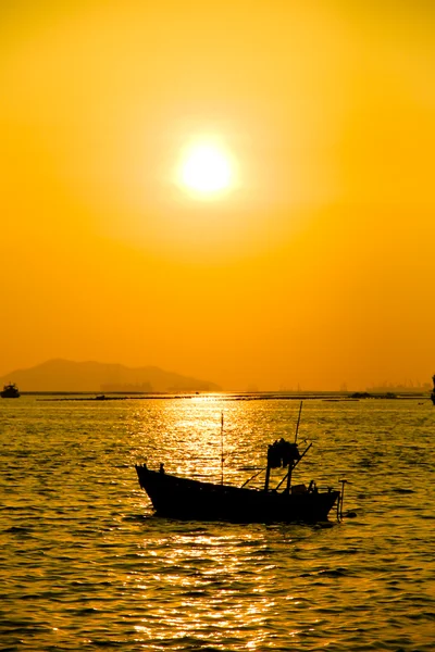 Silhuetter av båter ved solnedgang – stockfoto