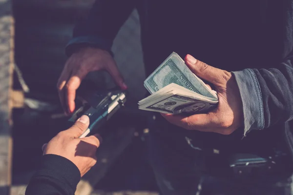 Homem comprando uma arma por dinheiro — Fotografia de Stock