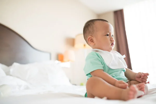 Kid sitting on the bed — Stock Photo, Image