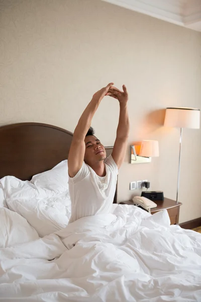 Man die zich uitstrekt in bed — Stockfoto