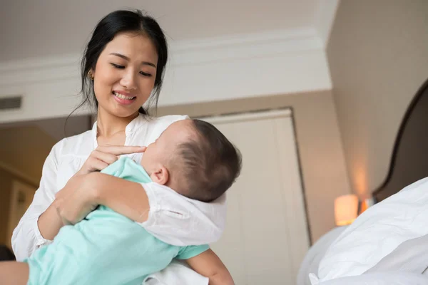 Mor leende när man tittar på hennes baby — Stockfoto