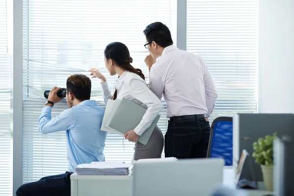 Folk tittar genom fönstret office — Stockfoto