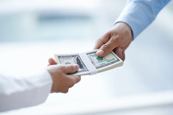 Mãos de homem de negócios dando dinheiro — Fotografia de Stock