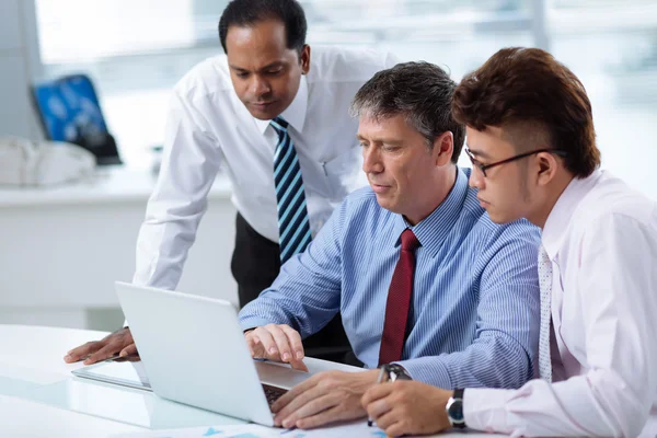 Business team gathered at laptop — Stock Photo, Image