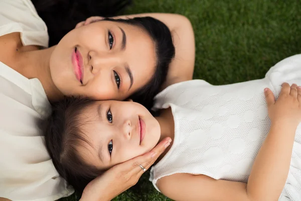 Mother and daughter lying on grass — Stock Photo, Image