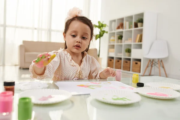 Meisje maken van kleurrijke handafdrukken — Stockfoto