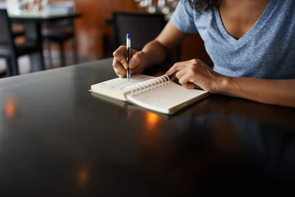 Mulher escrevendo no bloco de notas — Fotografia de Stock