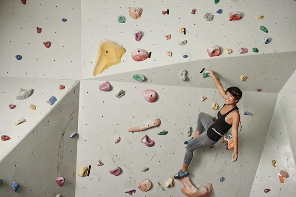 Woman climbing up the wall — Stock Photo, Image