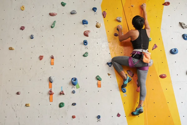 Kvinna klättrar upp på väggen — Stockfoto