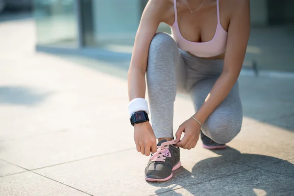 Vrouwelijke jogger koppelverkoop schoenen — Stockfoto