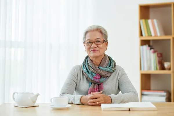 Sorridente donna anziana seduta — Foto Stock