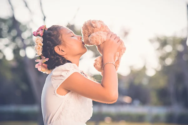 Девушка целует своего игрушечного медведя — стоковое фото