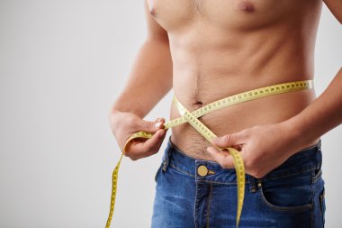 Adam belini ölçüyor. 