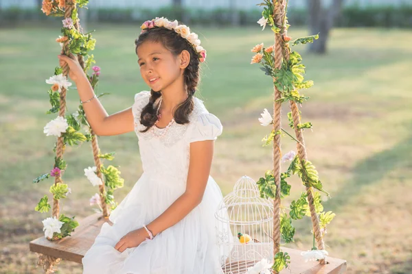 Menina em coroa floral balançando — Fotografia de Stock