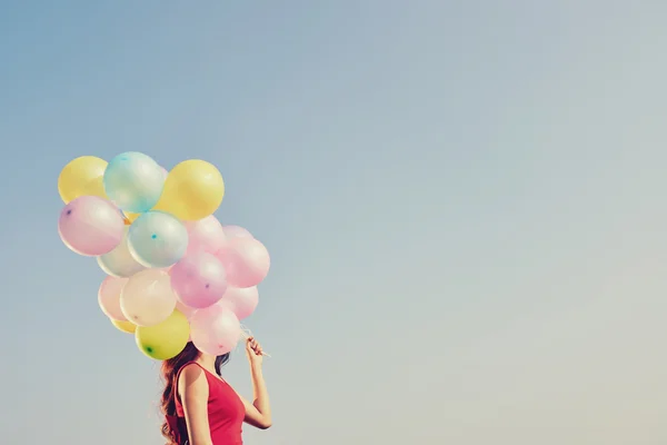 Mädchen mit bunten Luftballons — Stockfoto