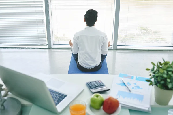 Empresário meditando no escritório — Fotografia de Stock