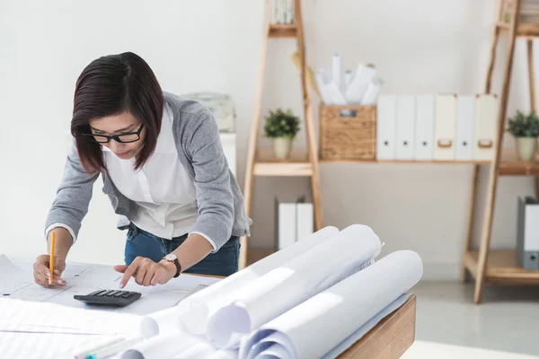 Female designer checking blueprint — Stock Photo, Image