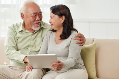 Dijital tablet kullanan yaşlı çift