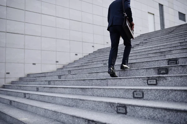 Persona de negocios subiendo escaleras — Foto de Stock