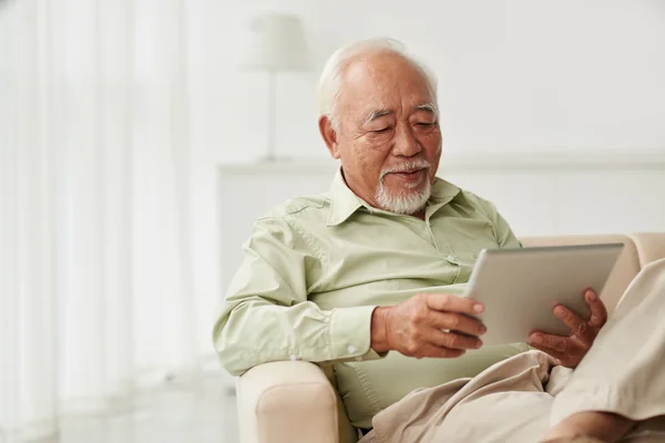 Man reading news on tablet — Stock Photo, Image