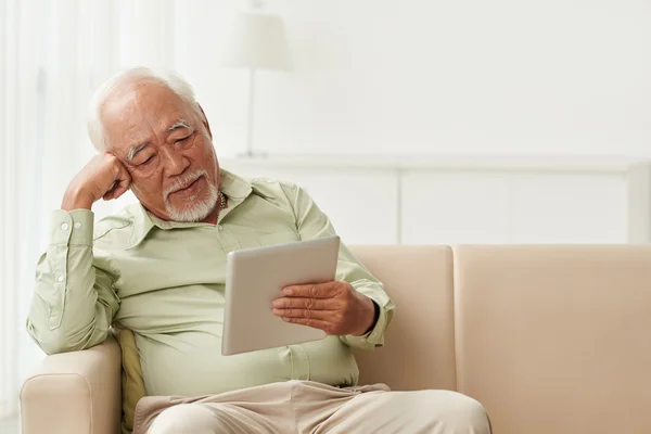 Mann liest Buch auf Tablet — Stockfoto
