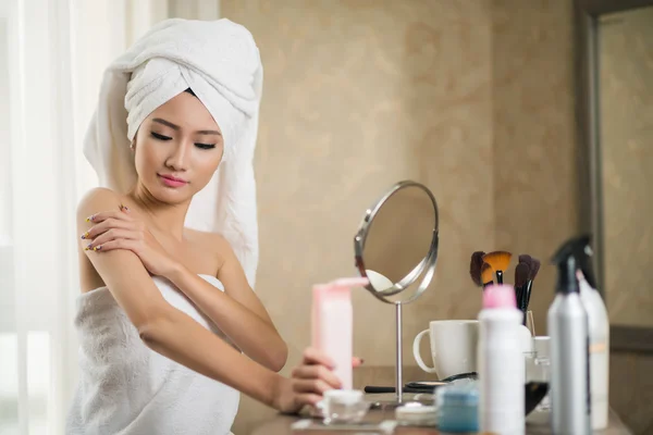 Beautiful woman applying lotion — Stock Photo, Image