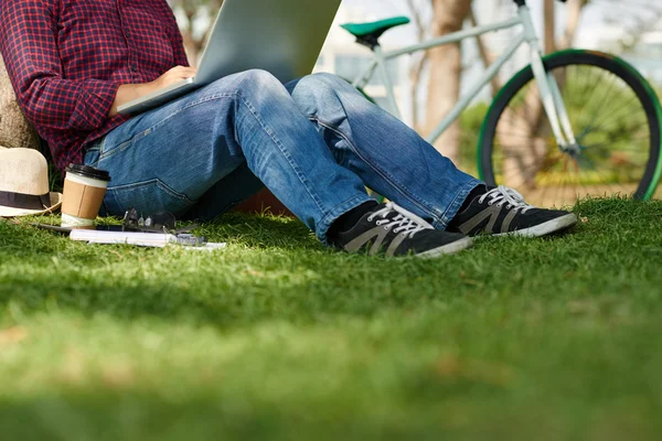 Man in het park die op laptop werkt — Stockfoto