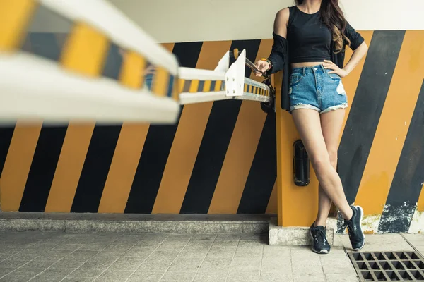 Flickan står på svarta och gula barriären — Stockfoto