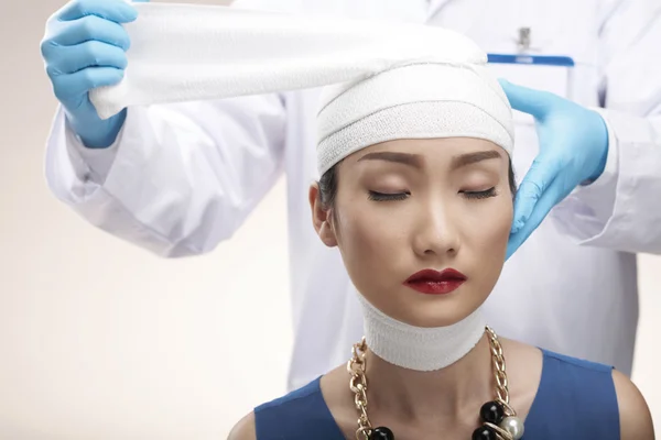 Chirurgo bendaggio testa di donna — Foto Stock