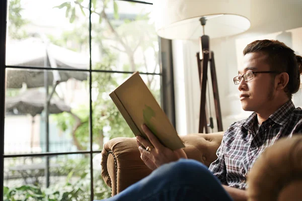 Hombre leyendo libro en casa — Foto de Stock