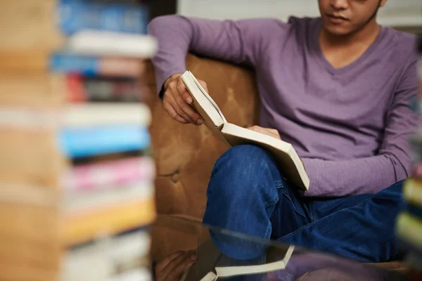 Homem desfrutando de livro na biblioteca — Fotografia de Stock