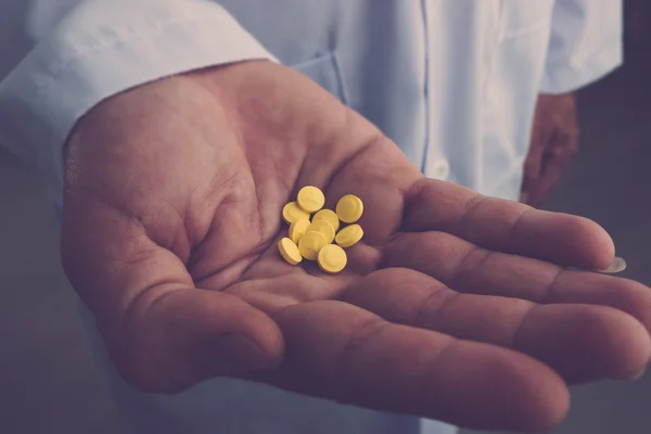 Lekarz gospodarstwa żółte tabletki — Zdjęcie stockowe