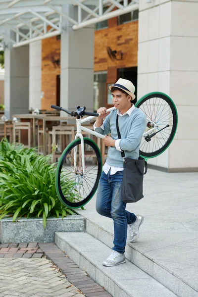 Young guy carrying bicycle — Stock Photo, Image