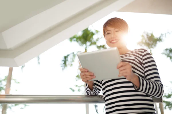 Frau schaut am Tablet-Computer zu — Stockfoto