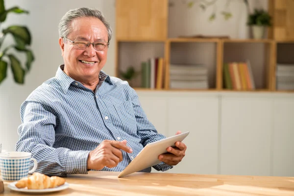 Homem alegre usando tablet — Fotografia de Stock